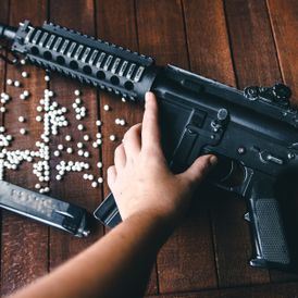 Airsoft rifle on wooden background