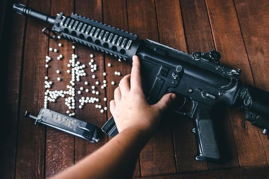 Airsoft rifle on wooden background